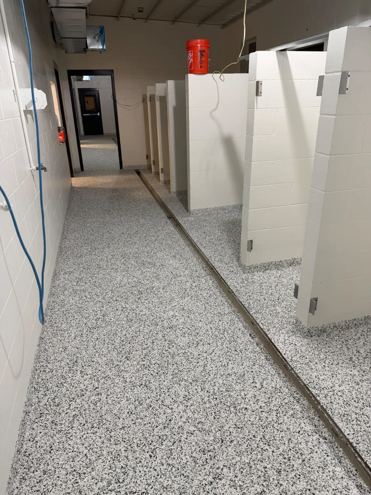 Seamless commercial wet-area resinous flooring with integrated floor drains